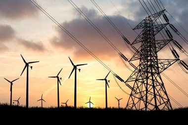 Gün batımında siluetli rüzgar türbinleri ve elektrik hatları yenilenebilir enerji ve modern altyapıyı renkli gökyüzüne karşı sergiliyor..
