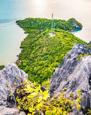 Mavi sular ve kayalık uçurumlarla çevrili yemyeşil bir adanın çarpıcı hava manzarası tropikal bir cennetin güzelliğini gözler önüne seriyor..