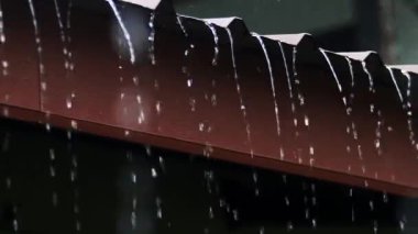 Gündüz vakti çatıdan yağmur damlıyor. Ağır çekimde yağmur yağar. 