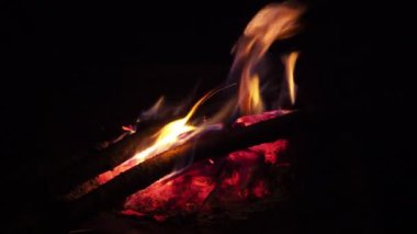 Yanan odunları olan bir şömine. Şöminede yangın var. Dinlenmek için rahat bir yer. Arka plan olarak ateş ve yakacak odun. Fırında yanan odun. Video ateşle