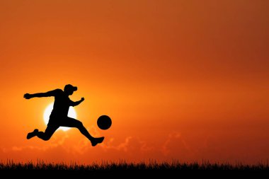 Futbol oyuncusunun dinamik silueti topu çarpıcı bir günbatımı arka planına vuruyor. Spor ve açık hava temaları için mükemmel..