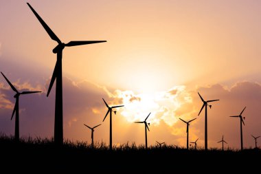 Siluetli rüzgar türbinleri, yenilenebilir enerji ve sürdürülebilirliği simgeleyen canlı bir günbatımı gökyüzüne karşı..