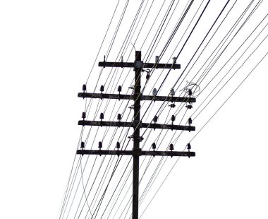 Beyaz gökyüzüne karşı çeşitli yönlere uzanan sayısız elektrik kablosu olan klasik bir tahta elektrik direği..