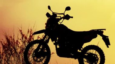 Çölde gün batımında motosiklet sürücüsü