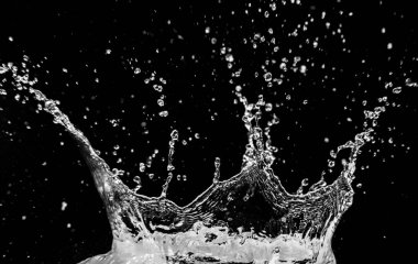 Su damlacıklarının yüksek hızda yakalanması, siyah bir zemin üzerinde asılı duran damlacıklar, sıvı dinamiklerini gösteriyor..