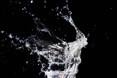 Suyun yüksek hızda yakalanması siyah arka plana sıçrar, hareket ve akıcılık gösterir..