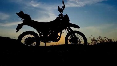 Yoldaki bir motosikletin silüeti.