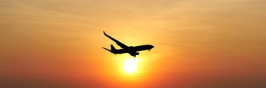 * * Uçak silueti rengarenk bir günbatımı gökyüzünde süzülüyor, seyahat ve maceranın özünü yakalıyor.
