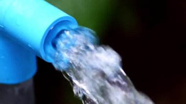 Mavi gömlekli, su damlacıklı bir adam.