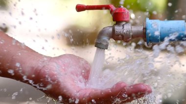 Ellerin musluktan su tutması, temiz su erişimi ve çevresel koruma.