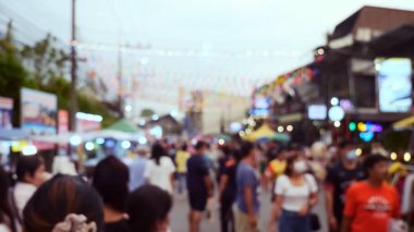 Bulanık kalabalıklar ve renkli süslemelerle dolu canlı bir sokak piyasa sahnesi, akşam pazarının canlı atmosferini yakalıyor..