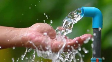 Su musluğu kullanan adam.