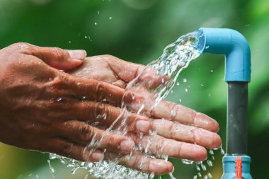 Bahçedeki su musluğu yeşil arkaplanlı..