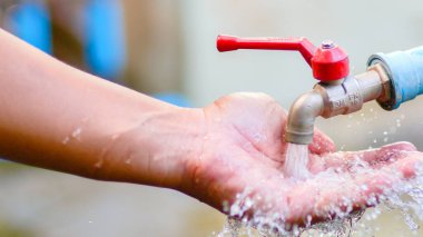 Çocuk bir çocuğun ellerini sabunla yıkıyor.