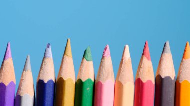 Mavi arkaplandaki renkli kalem seti, üst görünüm.