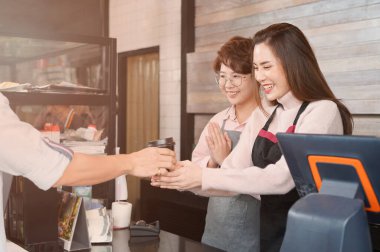 waitress serving coffee to customer at counter bar                               