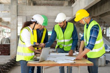 İnşaat alanında mühendislik takım çalışması, mühendislerin proje yöneticisi danışma toplantısı iş arkadaşlarıyla. Yeni bir emlak projesi için açık havada mühendislik veya mimarlık kavramı 