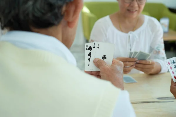 group of seniors joyful playing cards at home, concept elderly people lifestyle, hobbies, relaxation,relationship. selective focus