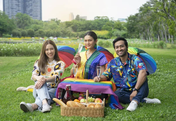 group of friends in colorful rainbow lgbt dresses having a picnic in the park on vacation, concept for lgbtq support, lgbtq pride month,lgbtq community equity