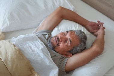 elderly man sleeping comfortably on bed, adequate sleep and effective sleep in the elderly, sleep is an essential function that allows senior body and mind to recharge                               