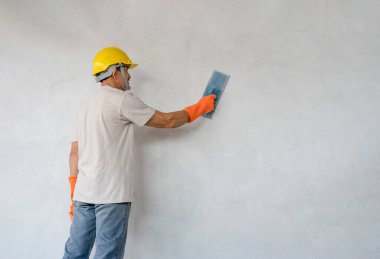 a man holding trowel plaster cement wall, concept of plaster work,home building, house renovation