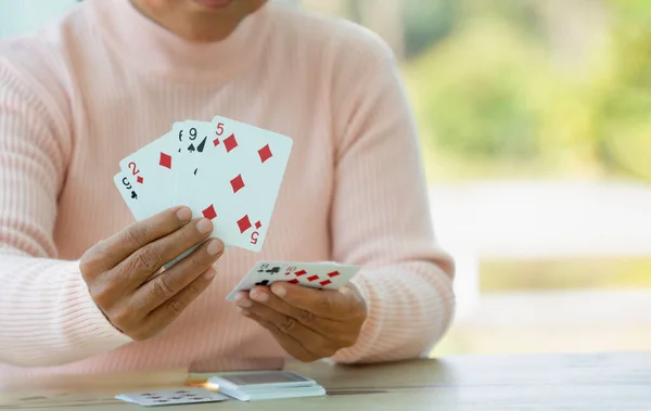 active senior pensioner woman playing cards with copy space, concept elderly retired people entertainment,encourages social interaction,help memory retention