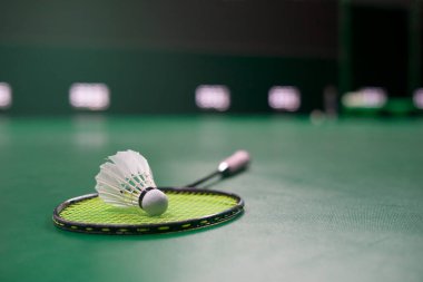 white shuttlecock put on racket on floor badminton court, selective focus