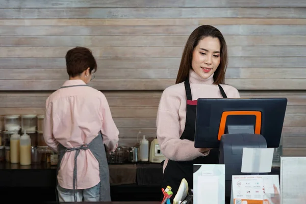 happy asian female wears apron working at cash register counter, young successful woman coffee business owner, SME business