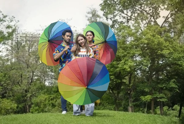 concept lgbtq community equality movement, proud to be gay, lgbtq happy pride month, young diverse friends in colorful rainbow dress in the park