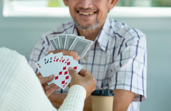 happy senior couple enjoy playing cards game together, concept elderly pensioner lifestyle, entertainment, recreation, encourages social interaction, help memory retention