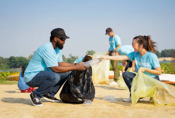 A diverse group of volunteers join together to cleanup the sand beach,collect garbage,separate waste.concept of global warming issue,reduce the impact of waste on the environment,save the planet
