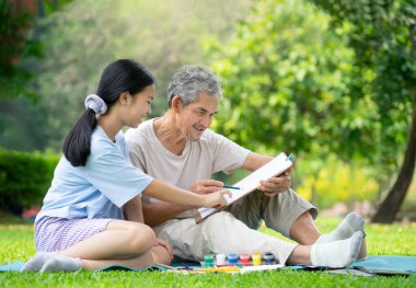 Asyalı son sınıf öğrencisi erkek ve kız çocuğunun parkta oturduğu portre, büyükbaba ve torun birlikte boş zamanlarını çizim, konsept aile hayatı, ilişki, aktivite, hobiler, tatiller, ergen yetiştirme ile geçiriyorlar.