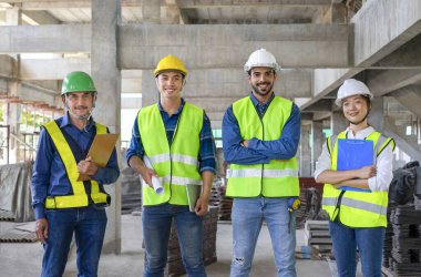 Yapı aşamasında çalışırken ayakta duran ve kameraya bakan çeşitli mühendislerin portresi. Mühendislik işi kavramı, inşaat alanında çalışan mühendis.