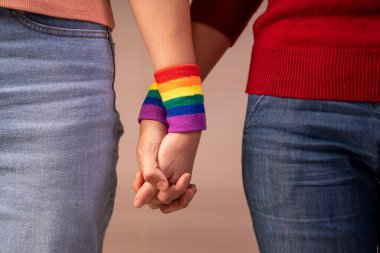 Romantik lezbiyen aşıklar birbirini destekleyen lgbt gökkuşağı bilekliği takarlar, lgbtq toplum eşitliği hareketi konsepti, lgbtq mutlu gurur ayı