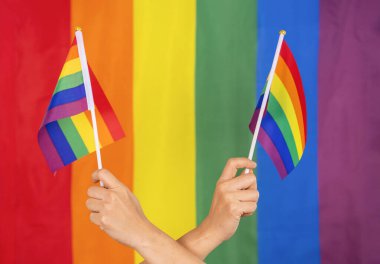 Renkli gökkuşağı gay bayrağı tutan eller, lgbt halkının sembolü, cinsiyet çeşitliliği aşk, romantizm, hoşgörü, kutlama, lgbtq toplum eşitliği hareketinin desteği, lgbt mutlu gurur ayı