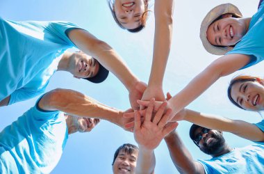 Düşük açı, bir grup mutlu çeşitlilik insanlar gülümser, desteklemek, güvenmek, yardım etmek için el ele tutuşurlar, dışarıda çalışırken bağlılık için gönüllü hayır işleri yaparlar.