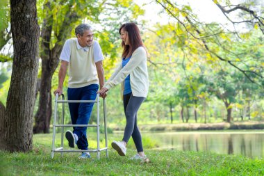 Aktif Asyalı kız çocuğu engelli babasıyla egzersiz, bahar parkında rehabilitasyon, insan yaşam tarzı, tatil, aile, ilişki, doğada sağlık sigortası