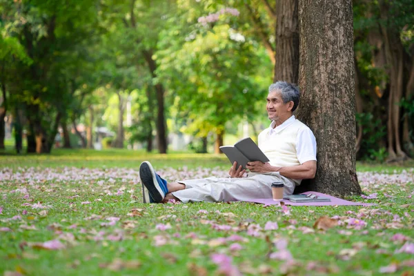 Retrato Feliz Anciano Sentado Contra Árbol Leyendo Libro Parque Natural Fotos de stock