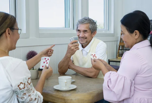 group of old pensioners playing cards at home,concept of senior freetime, recreation,entertainment,playing cards game is one of the activities that encourages social interaction,help memory retention