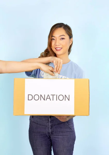 Una Voluntaria Usa Una Camiseta Azul Sosteniendo Una Caja Donación Fotos de stock