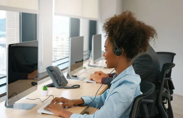 african american female wear headsets is working in a call centre, business woman operator agent is answering phone online