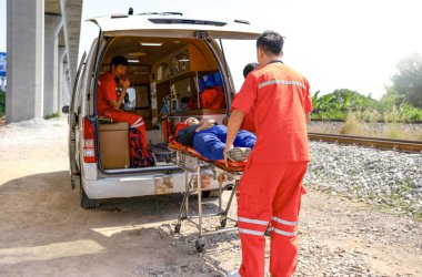 Asyalı acil servis ekibi, tren rayları bölgesinde kaza geçiren bir adama yardım ediyor.