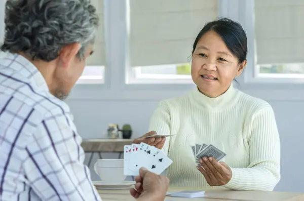 active senior pensioners playing cards game together, concept elderly retired people entertainment,encourages social interaction,help memory retention