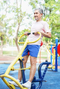Sağlıklı bir son sınıf öğrencisi streç makinesinde egzersiz yapar, olgun bir adam parkta spor yapar.     