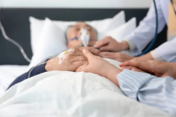 Bir eşin el ele tutuşması, oksijen ve damar içi solüsyonu olan umutsuz yaşlı bir hastayı yatağa yatırması, doktorun ölmekte olan bir hastayı muayene etmesi, palyatif bakım kavramı, yaşam tedavisinin sona ermesi.