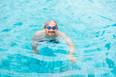 Havuzda yüzen son sınıf öğrencisi, sağlıklı yaşam tarzı, egzersizi, sportif yaşlı bir erkek.