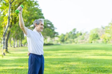 Doğa parkında halterle egzersiz yapan sağlıklı Asyalı kıdemli bir adam. Yaşlılar sağlık hizmetleri, egzersiz, sağlık ve refah kavramı.