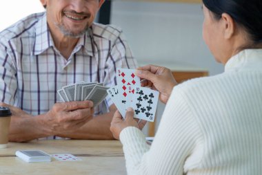 Mutlu Asyalı üst düzey çiftler kart oynamayı seviyorlar, yaşlılar yaşam tarzı, eğlence, eğlence, sosyal etkileşimi teşvik ediyor, hafızayı korumada yardımcı oluyor. 