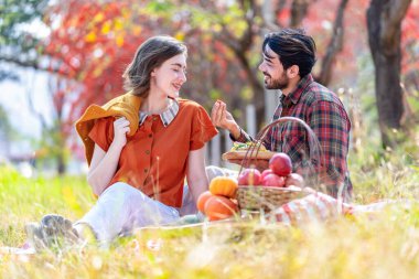 Kafkas ailesi sonbahar parkında piknik yapıyor. Genç romantik çift, sonbahar hasadını birlikte harika bir çayırda kutluyor.