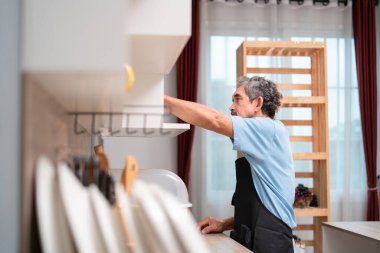 Mutfakta çalışan meşgul bir son sınıf öğrencisi, yaşlılar, ev hayatı, yemek pişirme